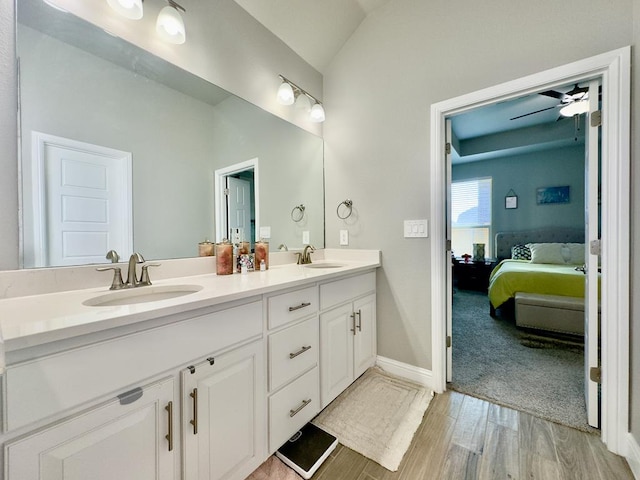 bathroom with a ceiling fan, vaulted ceiling, a sink, and double vanity