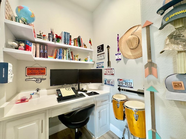 office area with light wood-type flooring and built in desk