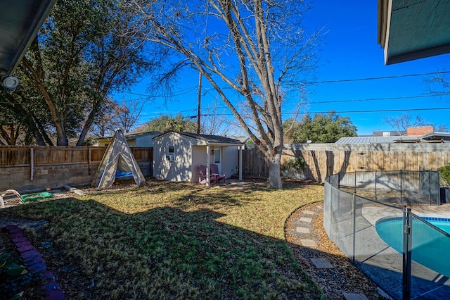 view of yard with a storage shed and a fenced in pool