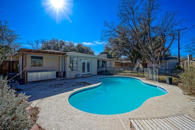 view of swimming pool featuring a jacuzzi, french doors, and a patio