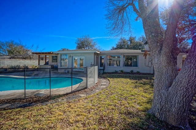 view of swimming pool with a lawn, french doors, and a patio area