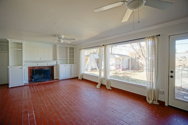 unfurnished living room featuring a brick fireplace, ceiling fan, and ornamental molding