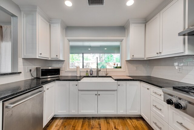 2603 Hughes St, Midland, TX 79705 - kitchen with stainless steel appliances, white cabinetry, range hood, decorative backsplash, and recessed lighting