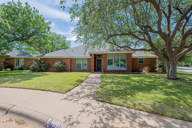 ranch-style house with a front yard and brick siding