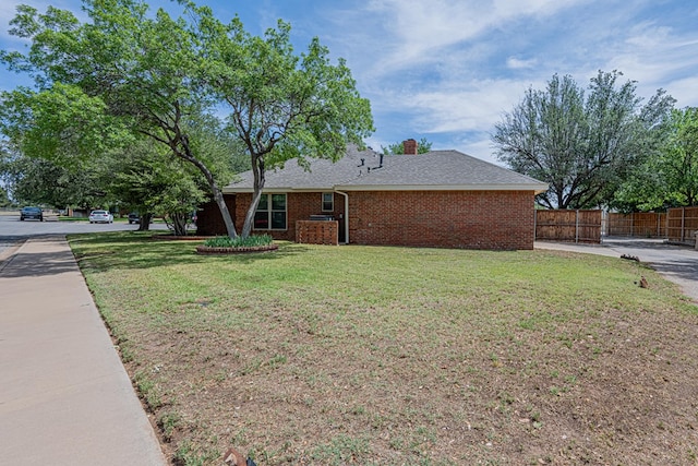 view of side of home featuring brick siding, a shingled roof, and a chimney