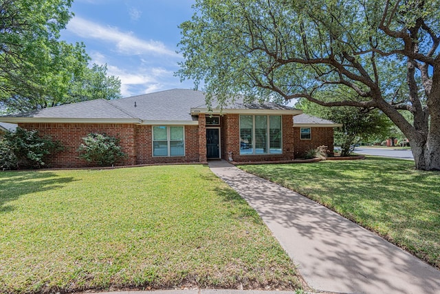 ranch-style house with a front yard and brick siding
