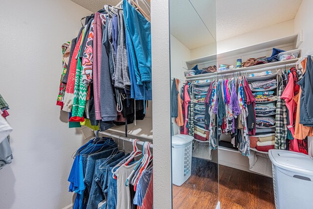 walk in closet with wood finished floors
