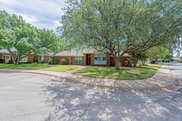 view of front of home featuring a front lawn and brick siding