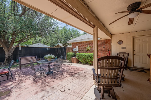 view of patio / terrace with outdoor dining area, fence, and a ceiling fan