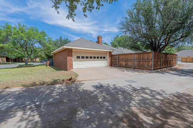 view of property exterior with brick siding, a chimney, and driveway