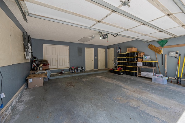 garage with a garage door opener and electric panel