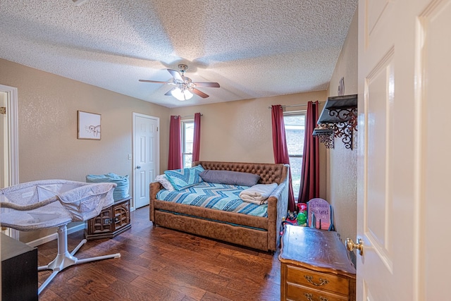 bedroom featuring a textured ceiling, wood finished floors, a ceiling fan, and a textured wall