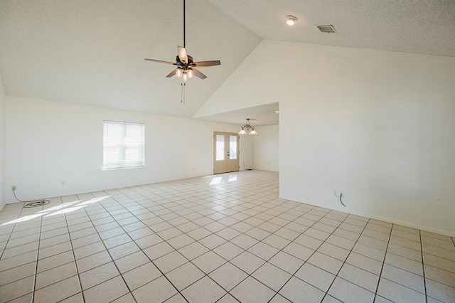 tiled empty room with a textured ceiling, high vaulted ceiling, and ceiling fan with notable chandelier