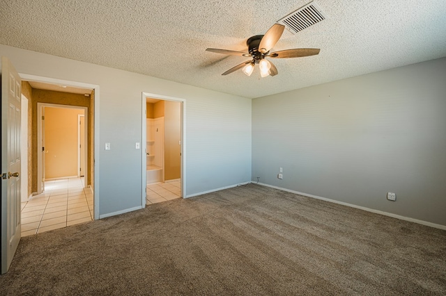 unfurnished bedroom with ensuite bath, ceiling fan, light colored carpet, and a textured ceiling