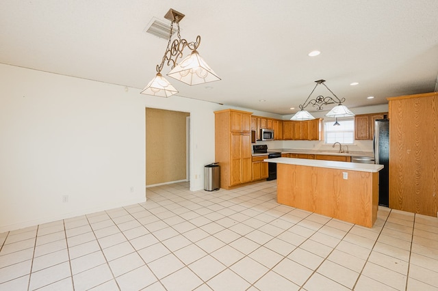 kitchen featuring sink, light tile patterned floors, appliances with stainless steel finishes, decorative light fixtures, and a kitchen island