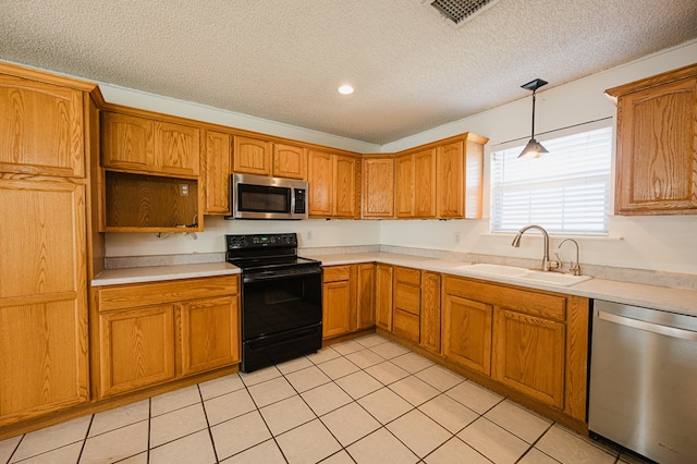 kitchen with pendant lighting, sink, appliances with stainless steel finishes, and a textured ceiling