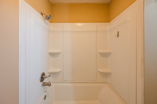 bathroom with a textured ceiling and  shower combination