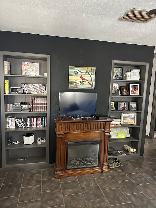 interior space featuring built in shelves and a textured ceiling