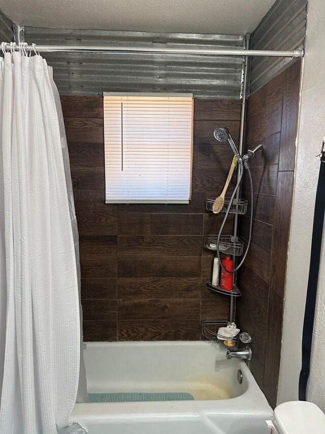 bathroom with shower / tub combo and a textured ceiling