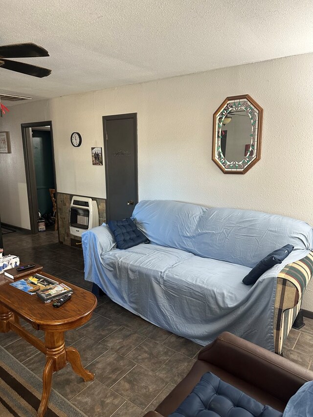 living room with a textured ceiling, heating unit, and ceiling fan