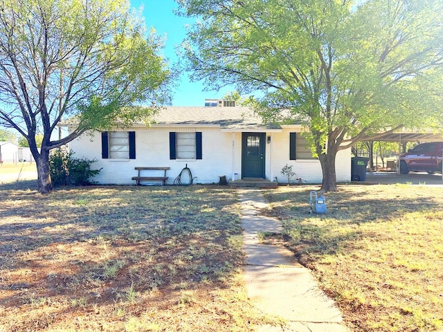 ranch-style house with a carport and a front lawn