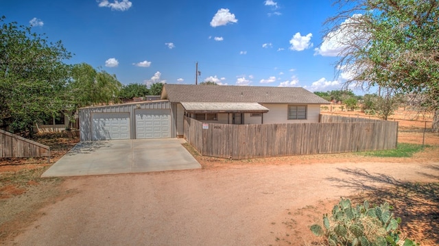 ranch-style house with a garage, concrete driveway, and fence private yard