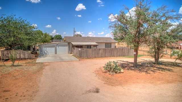 view of front of house with an attached garage, driveway, and fence private yard