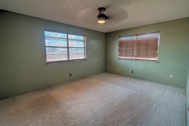 unfurnished room featuring ceiling fan, carpet, and a textured ceiling