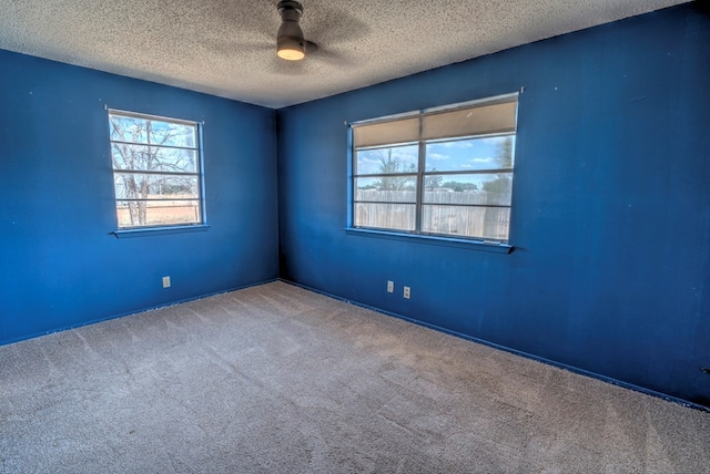carpeted empty room with a ceiling fan and a textured ceiling