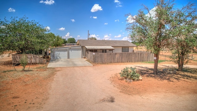 view of front of property with an attached garage, fence, and driveway