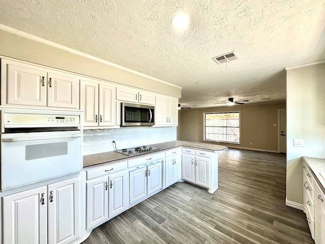 kitchen featuring white cabinetry, ceiling fan, kitchen peninsula, oven, and light hardwood / wood-style floors