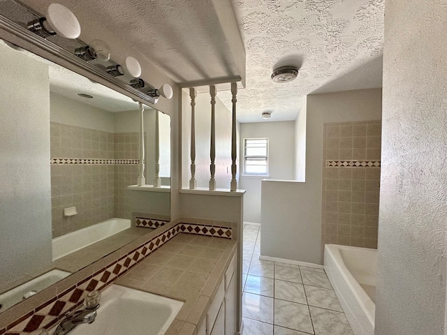 bathroom with a tile shower, tile patterned flooring, vanity, and a textured ceiling