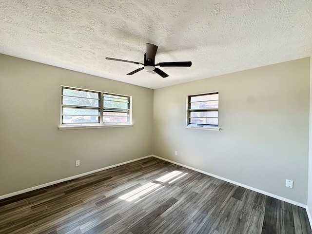 empty room with a textured ceiling, dark hardwood / wood-style flooring, ceiling fan, and a healthy amount of sunlight