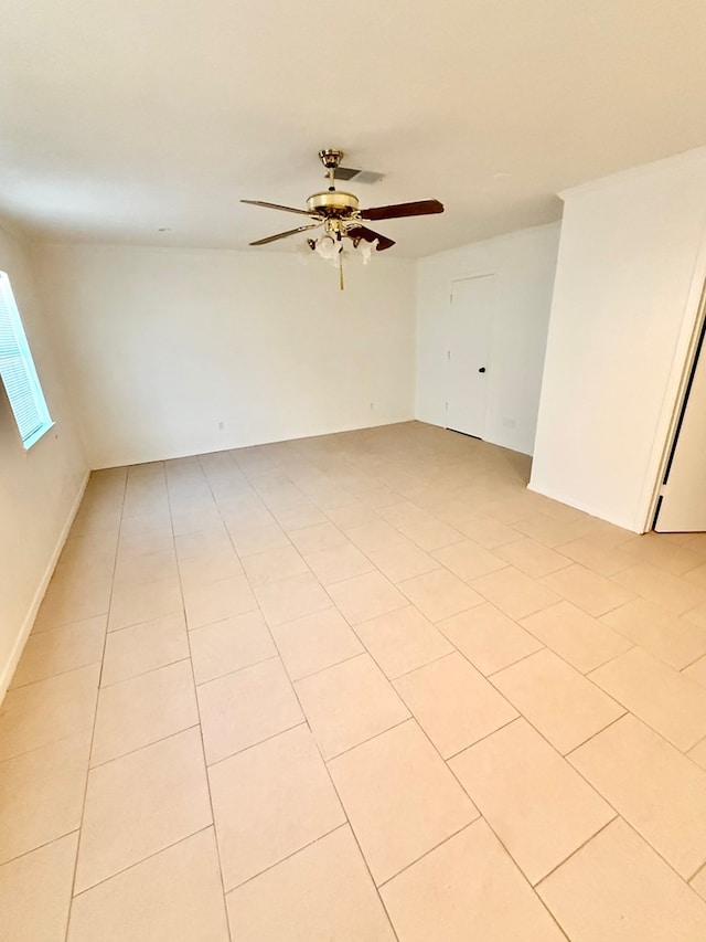 tiled spare room with ceiling fan