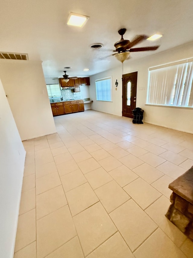 unfurnished living room featuring light tile patterned flooring and ceiling fan