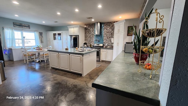 24501 S County Rd 1210, Midland, TX 79706 - kitchen featuring stainless steel appliances, finished concrete floors, white cabinetry, a kitchen island with sink, and wall chimney range hood