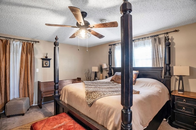 bedroom with a ceiling fan, carpet, and a textured ceiling