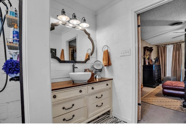 bathroom featuring vanity, baseboards, visible vents, ornamental molding, and a textured ceiling