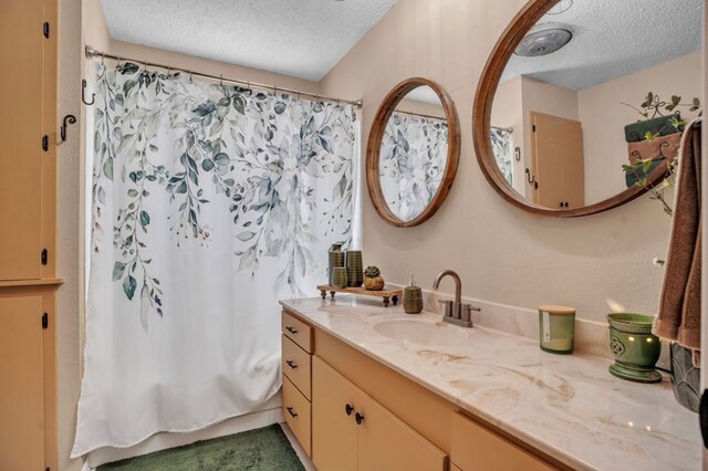 full bathroom featuring vanity and a textured ceiling