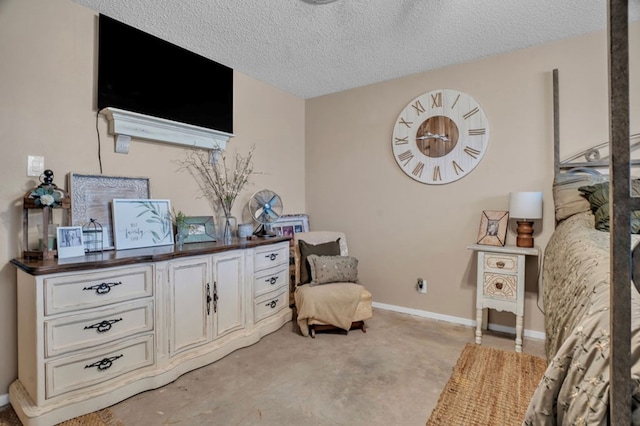 living area with a textured ceiling, concrete flooring, and baseboards