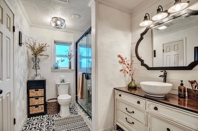 bathroom featuring a textured ceiling, vanity, crown molding, and a textured wall