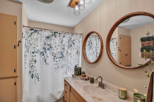 full bath featuring curtained shower, a textured ceiling, and vanity