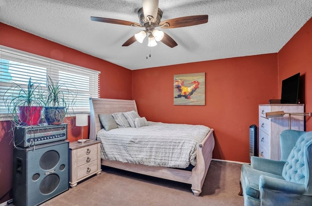 bedroom with carpet floors, a textured ceiling, and a ceiling fan