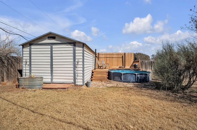 view of shed with an outdoor pool and a fenced backyard