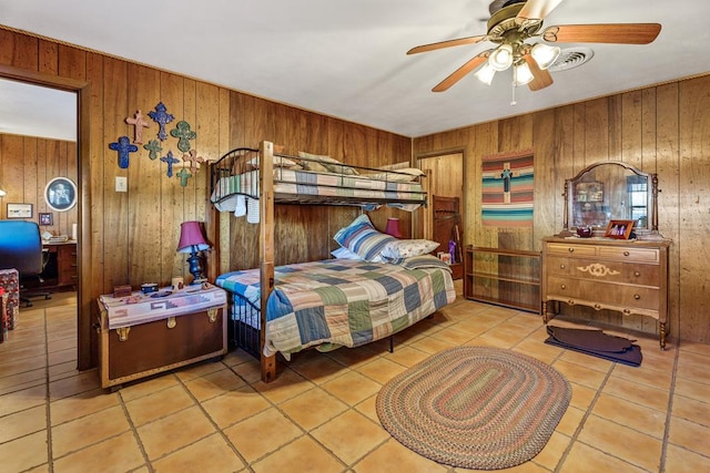 tiled bedroom featuring ceiling fan and wood walls