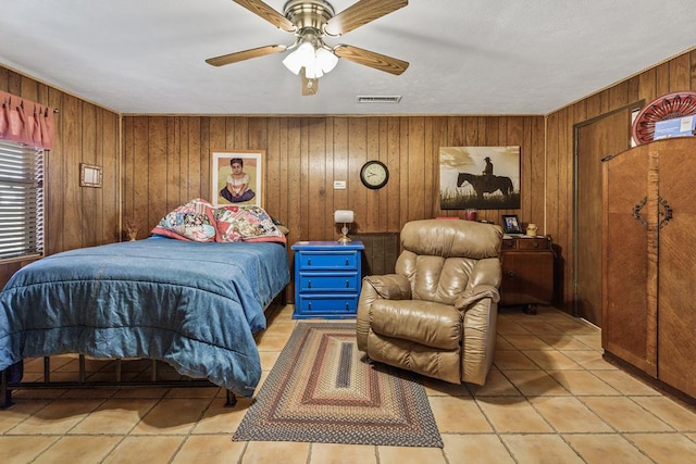 tiled bedroom with ceiling fan and wood walls