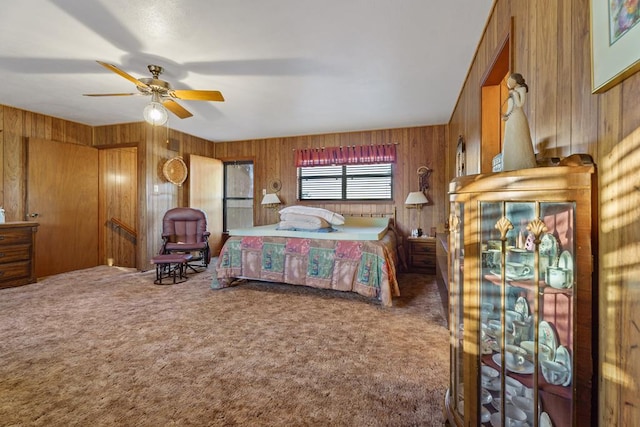 carpeted bedroom with ceiling fan and wooden walls