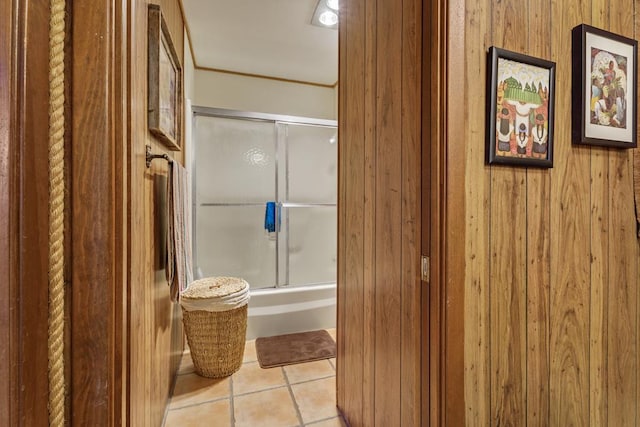 bathroom with wood walls, tile patterned flooring, and walk in shower