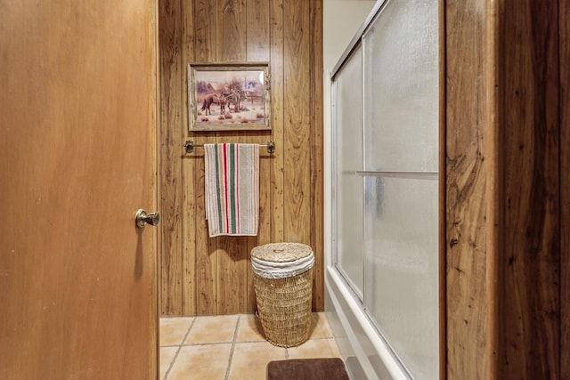 bathroom featuring tile patterned floors, wooden walls, and walk in shower