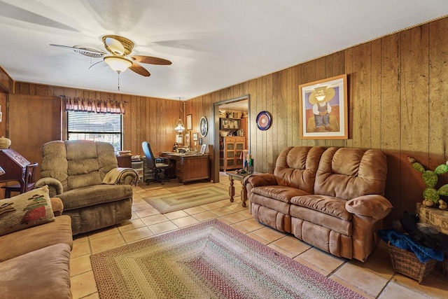 living room with light tile patterned floors, ceiling fan, and wood walls